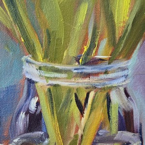 Puede incluir: Una pintura al &oacute;leo de un jarr&oacute;n de vidrio lleno de tallos verdes y flores rojas y rosas. El jarr&oacute;n tiene un borde plateado y se asienta sobre una superficie clara. La obra de arte est&aacute; realizada con pinceladas visibles.