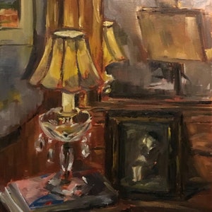 May include: A still life painting of a lamp with a yellow lampshade, a framed picture, and a stack of books on a wooden table.