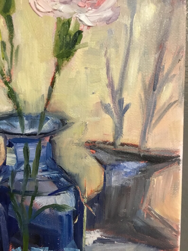 May include: An oil painting depicts a still life of flowers in blue vases. The flowers are light pink and white, with green stems and leaves. The vases are a deep blue, and the background is a soft yellow.