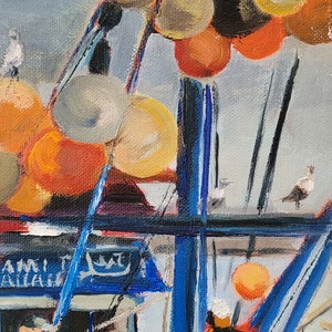 Op de afbeelding: Olieverfschilderij van een vissersboot met blauwe en zwarte accenten, met oranje en gele boeien. Het kunstwerk toont zeemeeuwen en de structuur van de boot, met zichtbare tekst op de zijkant.