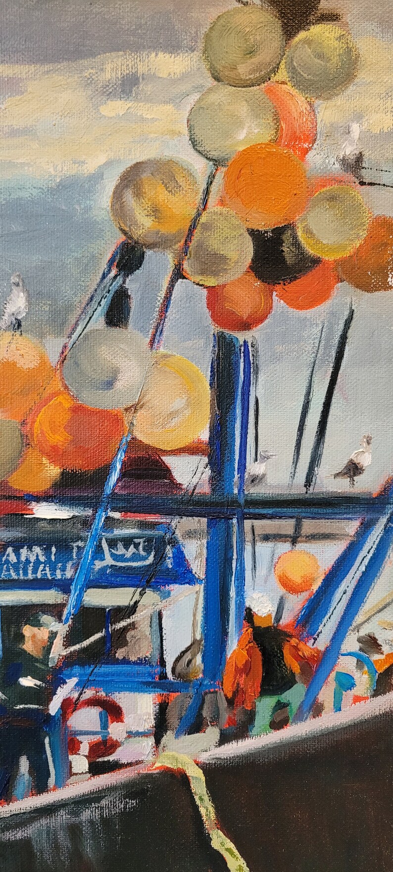 Op de afbeelding: Olieverfschilderij van een vissersboot met blauwe en zwarte accenten, met oranje en gele boeien. Het kunstwerk toont zeemeeuwen en de structuur van de boot, met zichtbare tekst op de zijkant.