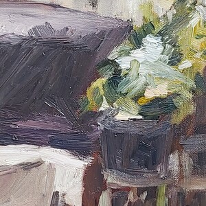 May include: A close-up of a painting depicting a potted plant with green leaves and white flowers. The plant is in a dark brown pot and is sitting on a table. The background is a light brown wall.