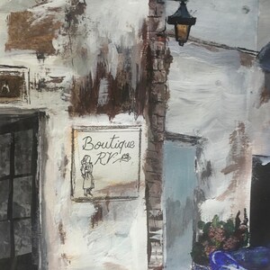 May include: A white building with a sign that reads "Boutique RV". The sign has a drawing of a woman in a dress. There is a street lamp on the side of the building.