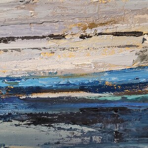 May include: Abstract oil painting with a textured surface. The artwork features horizontal bands of color, including shades of blue, white, gray, and gold. The brushstrokes create a sense of depth and movement, evoking a landscape or seascape.