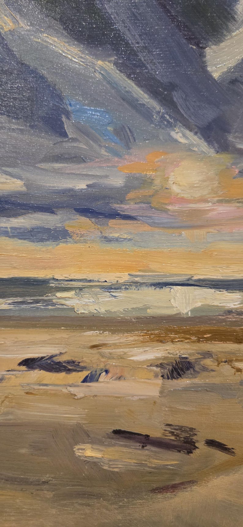 May include: An oil painting on canvas depicting a coastal landscape with thick, visible brushstrokes. The scene features a sandy beach in the foreground, a dark blue ocean with white-capped waves, and a dramatic sky filled with dark blue and orange clouds.