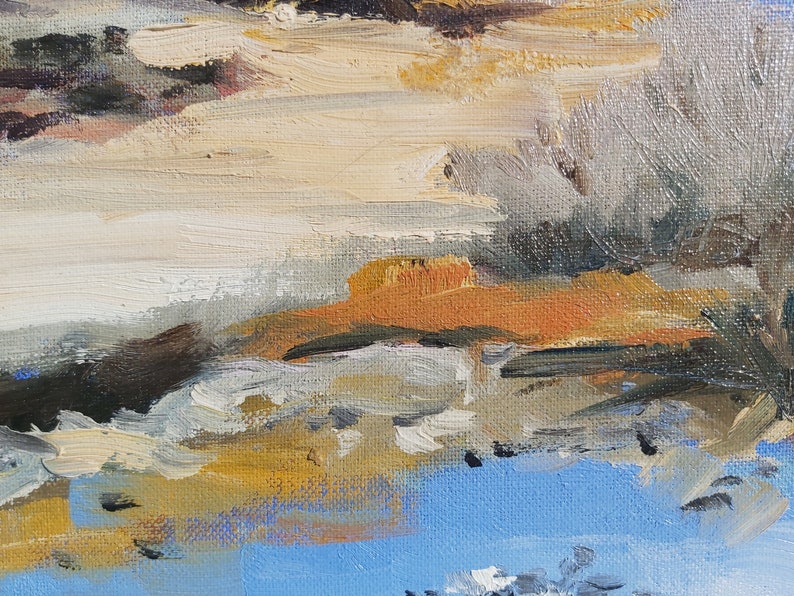 May include: Abstract painting with brushstrokes of white, brown, orange, and blue paint. The painting has a textured surface.
