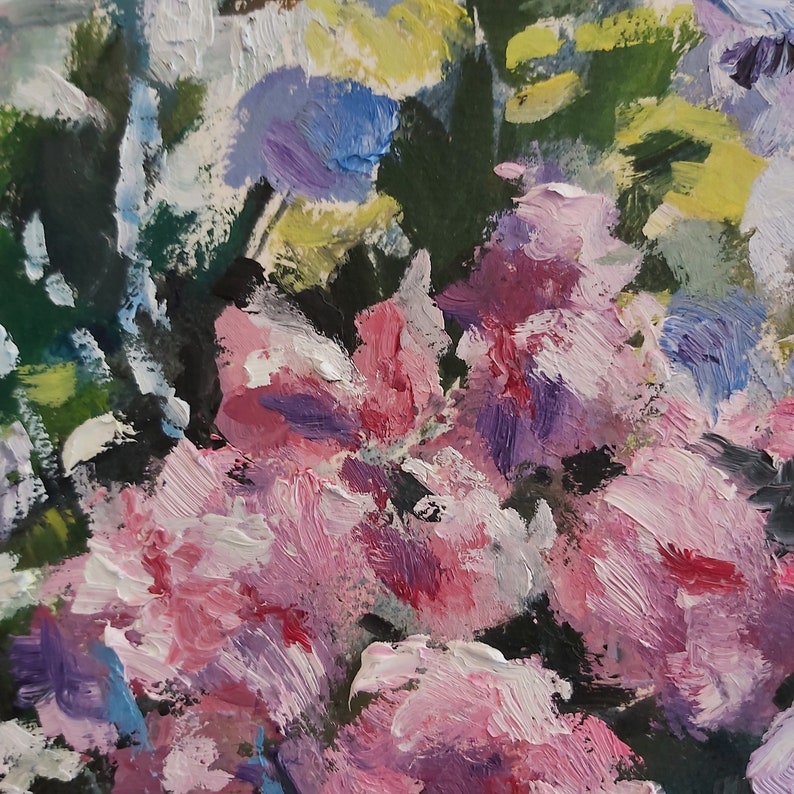 May include: Close-up of a painting of pink, purple, and blue flowers with green leaves. The flowers are painted in a loose, impressionistic style.