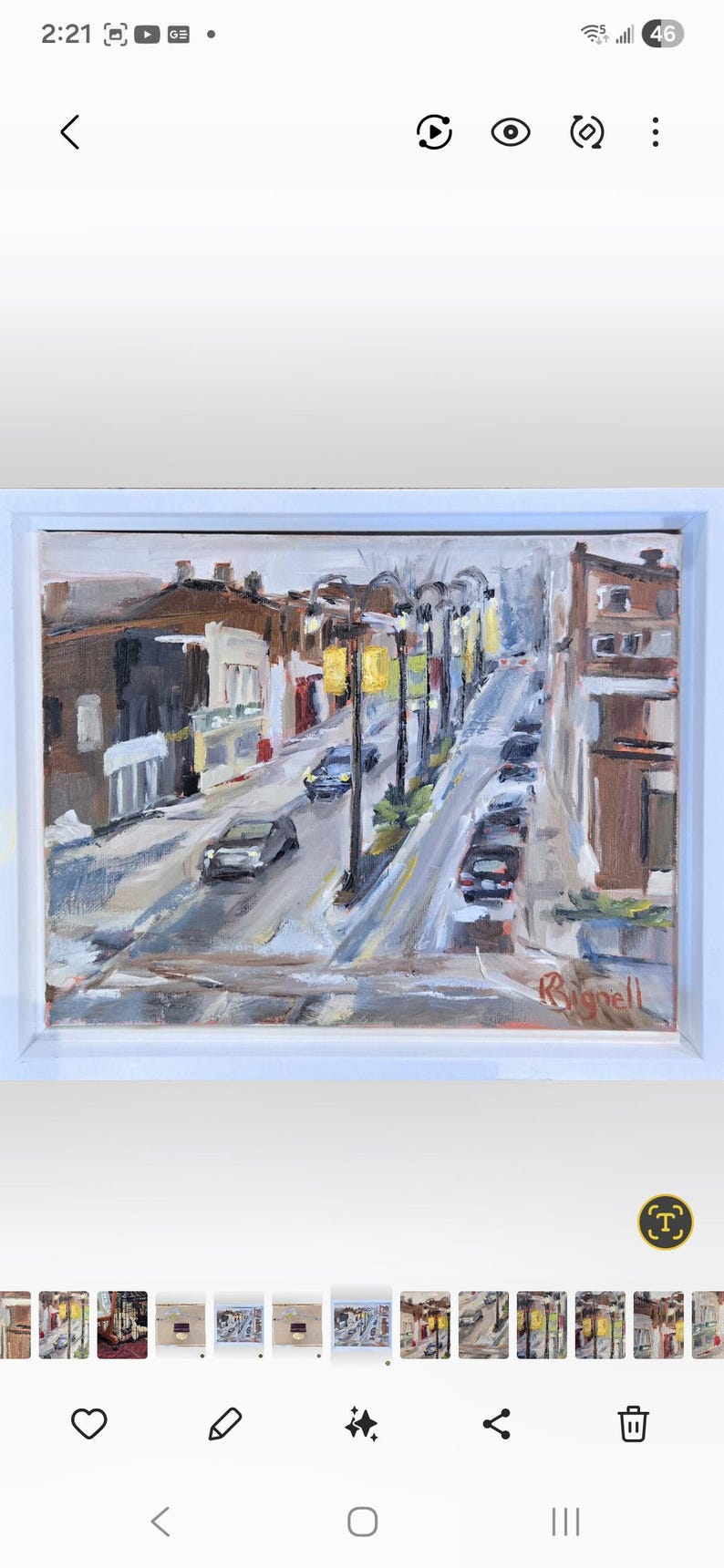 May include: An oil painting of a city street scene, framed in white. The artwork depicts a road with cars, streetlights, and buildings in shades of brown, gray, and white. The artist's signature is visible in the lower right corner.