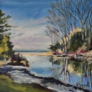 May include: A painting of a calm, blue river with a sandy shore and a line of trees on the far bank. The sky is a bright blue with white clouds. The trees are bare and reflected in the water.