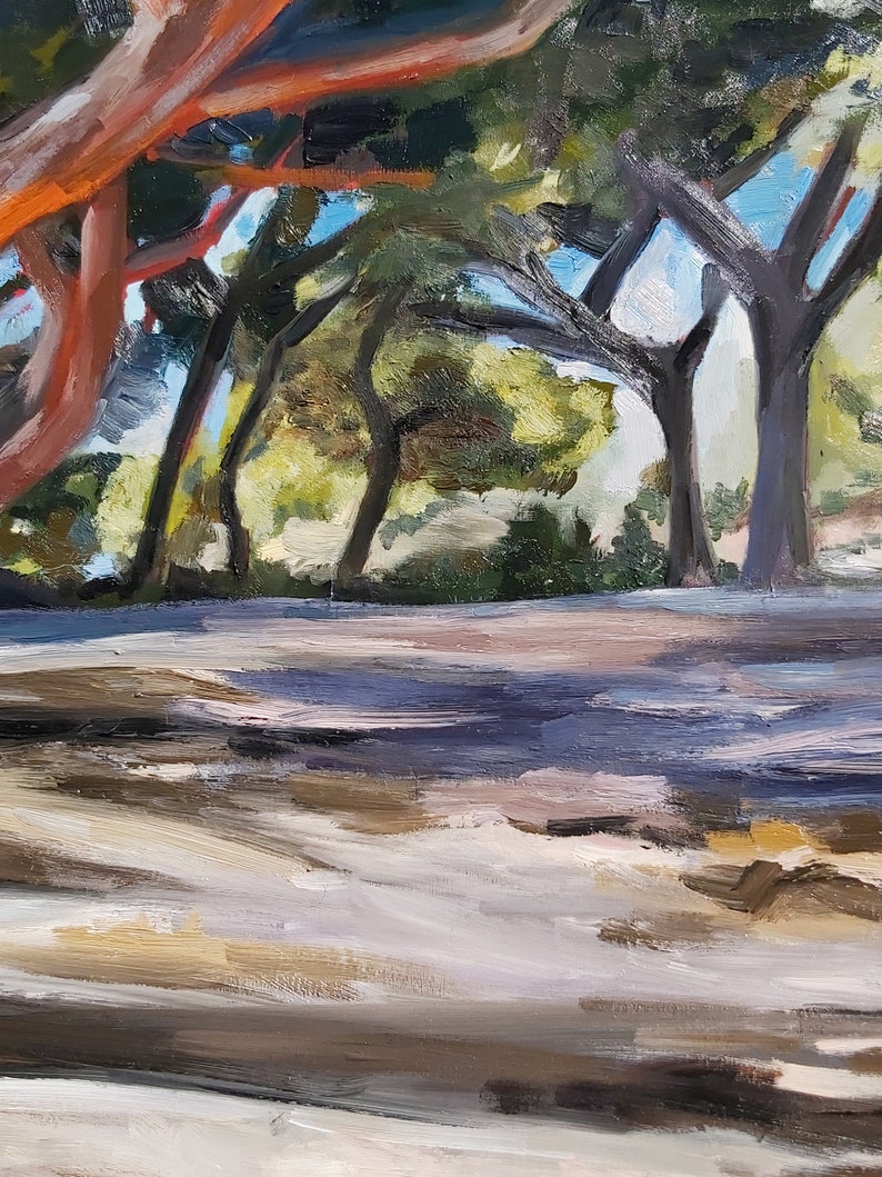 May include: An oil painting of a landscape featuring trees with reddish-orange trunks and dark green foliage. The painting depicts a path or ground area in shades of beige and brown, with shadows and sunlight creating depth and texture. The sky is a light blue.
