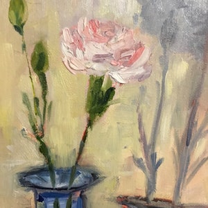 May include: Oil painting of a pink carnation flower in a blue vase. The flower is in full bloom with visible brushstrokes. Two green buds and stems are visible to the left. The background is a soft yellow with a gray shadow of a flower.