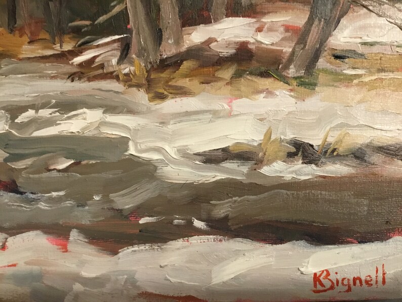 May include: A close-up of a painting depicting a snowy forest scene with a stream running through it. The artist's signature, "K. Bignell", is visible in the bottom right corner.