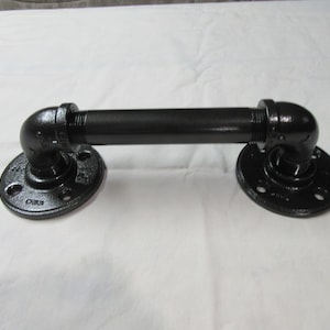 May include: Black metal pipe handle with two flanges. The handle is about 12 inches long.