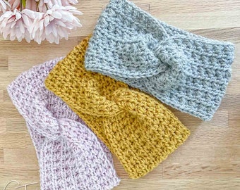 May include: Three crocheted headbands in different colours: light pink, mustard yellow, and light grey. The headbands are twisted and have a knot in the centre.