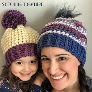 May include: Two people wearing crocheted hats. The hat on the left is cream and purple with a purple pom pom. The hat on the right is blue, purple, and white with a gray pom pom. The text "STITCHING TOGETHER" is at the top of the image.
