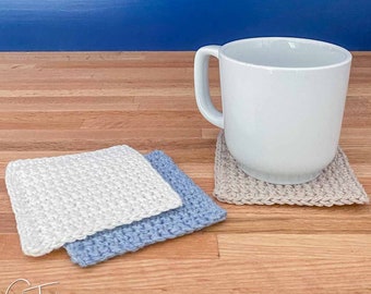 May include: Three crocheted coasters, one beige, one light blue, and one white, with a white ceramic mug sitting on the beige coaster. The coasters are on a wooden surface.