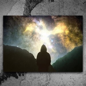 May include: A silhouette of a person standing in front of a mountain range, looking up at a bright, colorful nebula in the night sky.