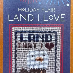 May include: A cross-stitch pattern with a patriotic theme. The design features an eagle and the text "LAND I LOVE" on a navy blue background with red and blue accents. The Bent Creek logo is in the upper left corner.