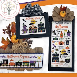 May include: Three cross stitch patterns for Halloween. The patterns are framed in black wood and feature a Halloween street scene, a Halloween train, and a list of "All the Things Halloween".