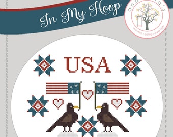 Può includere: Schema di punto croce con un design patriottico con la parola "USA" in rosso, due uccelli neri appollaiati su pecore bianche e stelle e bandiere rosse, bianche e blu.