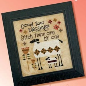 May include: Framed cross-stitch artwork featuring a sheep and lamb design with the text "Count Your Blessings, Stitch Them One by One." The artwork is in a black frame and has a cream-colored background.