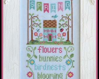 Op de afbeelding: Borduurpatroon met een charmant huisje met een blauwe deur en een banner met de tekst "Lente". Het patroon bevat ook bloemen, konijnen, vogelnesten, vlinders en buien. De tekst onder het huisje luidt "Bloemen, konijnen, vogelnesten, bloeiend, vlinders, buien".