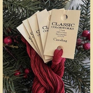 May include: Five spools of red embroidery floss with a label that reads "Classic Colorworks 5 Yards 100% Cotton Not Colorfast CCT-276 Caroling"