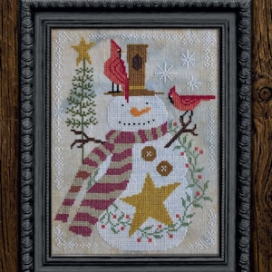 May include: A cross-stitch pattern featuring a snowman with a red and white striped scarf, a star, and two red cardinals. The pattern is titled "It's Snow Time" and is part of the "A Time for All Seasons Series #1" by Cottage Garden Samplings.