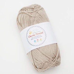 May include: A skein of beige chunky cotton yarn with a white label that reads "100% Cotton Chunky Thread by Tutti Frutti Knits of Melbourne, Australia."