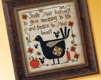 May include: A framed cross-stitch design featuring a black bird with a star-shaped design on its back. The bird is surrounded by pumpkins, leaves, and flowers. The text "Shale Your harvest to give meaning to life and peace to Your heart" is stitched in brown thread. The artist's signature "Cecilia Quner" is in the bottom right corner.