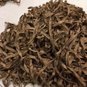 May include: A large pile of brown leather strips, tangled and knotted together. The strips are all the same width and appear to be cut from a larger piece of leather.