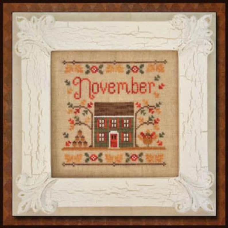 May include: Cross stitch pattern featuring a house with a red door, a rooster, and the word "November" in a brown frame.