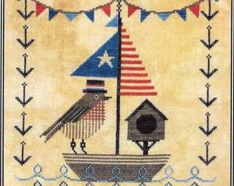 May include: Cross-stitch design featuring a bird in a patriotic boat with a star-spangled sail and striped sail. The design includes a birdhouse, anchors, and a banner of red, white, and blue flags. The background is a light tan color.