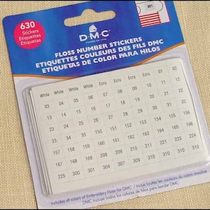 May include: A pack of DMC floss number stickers. The stickers are white with black numbers and are organized in a grid. The pack includes all colors of embroidery floss for DMC.