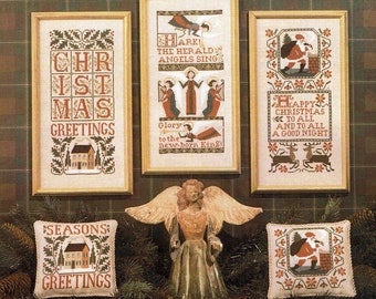 May include: Five framed cross-stitch patterns with a Christmas theme. The patterns include a house, angels, Santa Claus, and reindeer. The text on the patterns includes "Christmas Greetings", "Hark! The Herald Angels Sing", "Happy Christmas to All and to All a Good Night", and "Seasons Greetings".