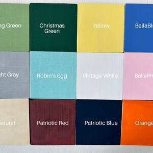 May include: Twelve paint color samples displayed on square wooden blocks. The colors are: Spring Green, Christmas Green, Yellow, BellaBlue, Light Gray, Robin's Egg, Vintage White, BellaPink, Natural, Patriotic Red, Patriotic Blue, and Orange.