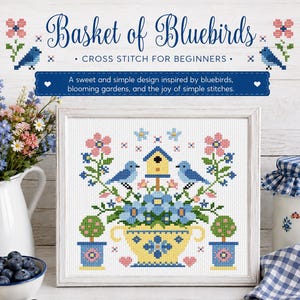May include: A framed cross-stitch design titled "Basket of Bluebirds" with the text "Cross Stitch for Beginners." The design features bluebirds, flowers, and a birdhouse in a yellow basket. The design is inspired by blooming gardens.