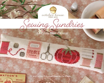 May include: A cross-stitch pattern for a pillow featuring a red spool of thread, a needle case, scissors, a pumpkin, and a spool of thread. The pattern is titled "Sewing Sundries" and is a "Skinny Mini Pattern" from October House Fiber Arts.