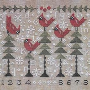 May include: Cross-stitch pattern featuring five red cardinal birds perched on green Christmas trees. The design includes snowflakes, the alphabet, and numbers 0-9. The background is a neutral beige color.