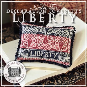 May include: A decorative pillow with the word "LIBERTY" embroidered on it. The pillow features a red, white, and blue design with a ruffled edge. The text "Number Two DECLARATION COVERLETS" is at the top, and the Summer House Stitche Workes logo is at the bottom.