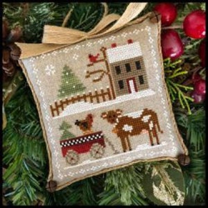 May include: A cross-stitch ornament featuring a winter scene with a red barn, a green tree, a red wagon with a brown and white dog pulling it, and a brown and white cow. The background is a snowy white with a brown fence.