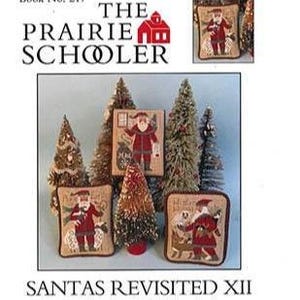 May include: A collection of Christmas-themed decorative items featuring Santa Claus. The items include framed artwork, pillows, and miniature Christmas trees. The text "THE PRAIRIE SCHOLER" and "SANTAS REVISITED XII" are visible.