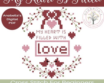 Op de afbeelding: Digitaal PDF kruissteekpatroon met de tekst "My Heart Is Filled With Love". Het ontwerp bevat een hart, bloemelementen en de woorden "Love" en "Cross Stitch For Beginners".