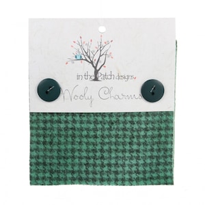 May include: A package of "Wooly Charms" featuring a green and black houndstooth patterned fabric sample with two dark green buttons. The card has a tree design and the text "in the Patch designs".