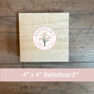 May include: A 4 inch by 4 inch unfinished wood square BellaBoard™ with a pink circle logo that says "anabella's craft - quilting - paper craft - home decor".