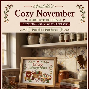 May include: A framed cross stitch chart titled Anabella's Cozy November from the Cozy Thanksgiving Collection. The design features a mug, a basket of supplies, and a quilt. The text reads Cozy November and Part of a 7-Part Series.