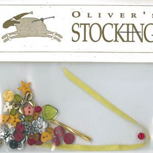 May include: A small plastic bag containing a variety of colorful buttons, a gold-colored pin, and a yellow ribbon. The bag is labeled "Oliver's Stocking".