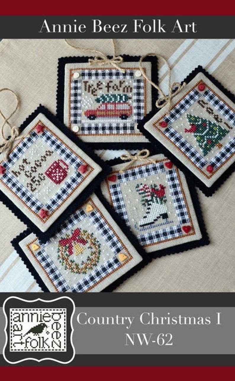 May include: Five cross-stitch ornament patterns featuring winter holiday themes. The patterns are framed in black and white gingham fabric and feature designs like a Christmas tree, a wreath, a car with a Christmas tree on top, a cup of hot cocoa, and a pair of ice skates. The patterns are titled "Country Christmas I" and "NW-62".