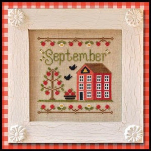 Op de afbeelding: Borduurpatroon met een rood huis met een groen dak, een rode appelboom met groene bladeren en rode appels, en een mand met rode appels. De tekst "September" is geborduurd in zwarte draad.