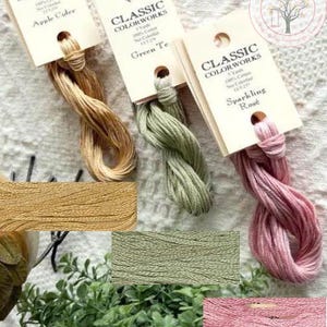 May include: Three spools of embroidery floss in the colors apple cider, green tea, and sparkling rose. Each spool is labeled with the Classic Colorworks brand name and the color name.